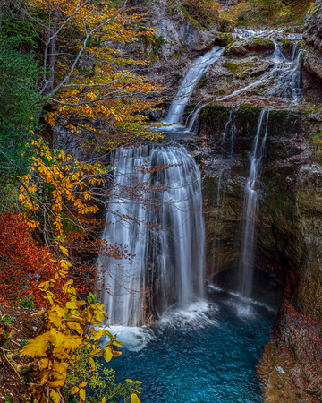 Waterfall Cave (Cave Fall), situated in the beautiful waterfall Arasas river in Ordesa NP, Spain. The exceptional beauty of the area is best appreciated in autumn When the surrounding forest turns into a kaleidoscope of vivid green, yellow, orange and redの写真素材