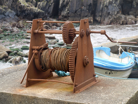 Rusty winch with fisherboats in Brandon Creek, Dingle Peninsula, Irelandの写真素材