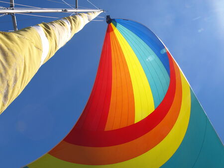 Colorful sail against a clear blue skyの写真素材