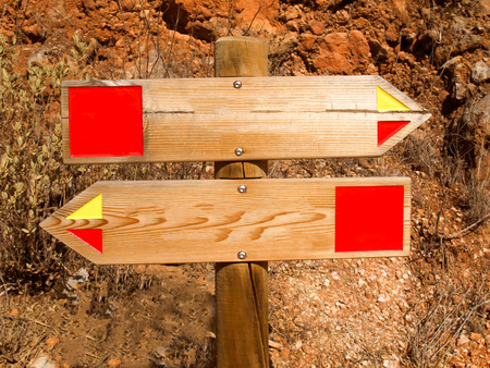 Wooden signs show in the opposite direction. Picture taken near Querenca in the Algarve in southern...