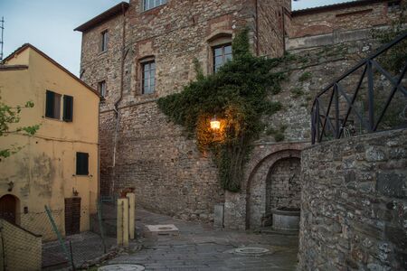 Street view in the evening light in the medieval tuscan town Lucignano.の写真素材