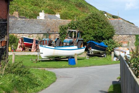Fishing boats with tractor in a backyard somewhere in Port Gaverne in Cornwall. Picture taken from a public street.の写真素材