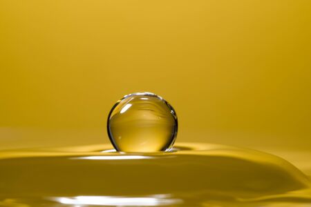 High speed macro from a waterdrop, splashing back again in the water, creating figurine like glass sculptures.の写真素材