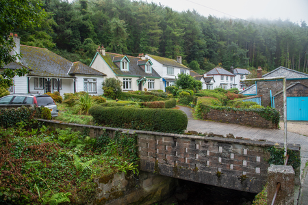 Old stone bridge with white cottages in the picturesque fishing village Polperro in south Cornwall, England. Picture taken from a public street.のeditorial素材