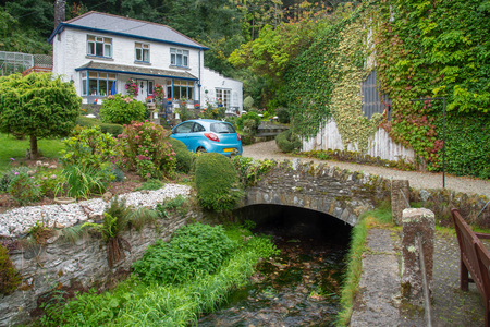 Old stone bridge with a white cottage in the picturesque fishing village Polperro in south Cornwall, England. Picture taken from a public street.のeditorial素材