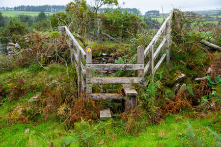 Wooden stile near St Breward in Cornwall, UK. Stiles allows persons a passage over the fence but prevents livestock to move from one enclosure to another.の写真素材