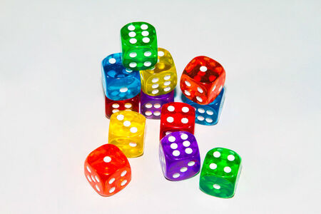 A sudio shot of twelve dice of various colors against a white background の写真素材