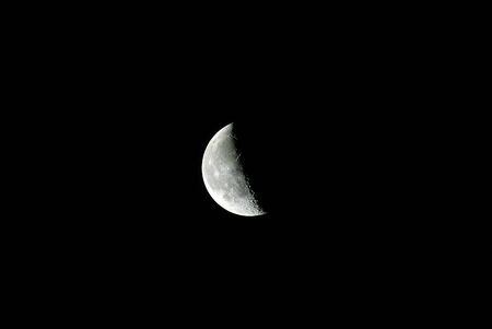 A picture of the moon in the night, with half of it being lit up diagonally の写真素材