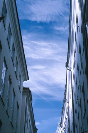 Side of buildings and sky on narrow streetの写真素材