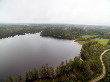 Cloudy day with a view of water surronded by forestの写真素材