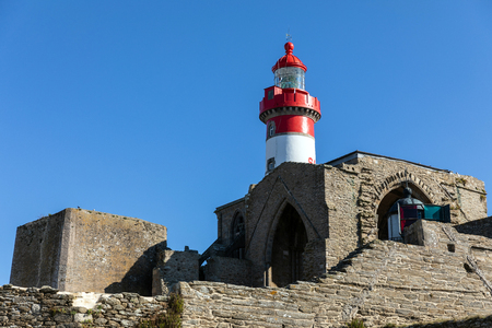 The Saint-Mathieu lighthouse behind the ruins of the abbey Saint-Mathieu de Fine-Terre in Plougonvelin (Finistere, France)の写真素材