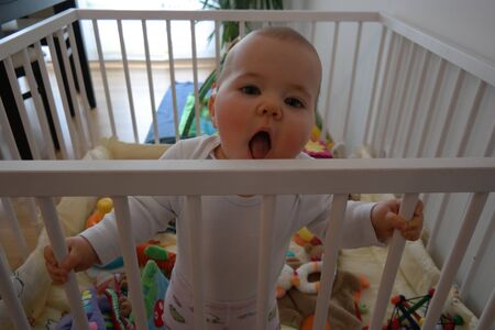 Baby sthet in Laufstall und schreitの写真素材