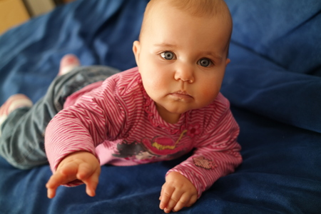 baby lying on his stomach on a couchの写真素材