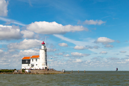 Marken lighthouse and fare off boats under Dutch blue skyの写真素材