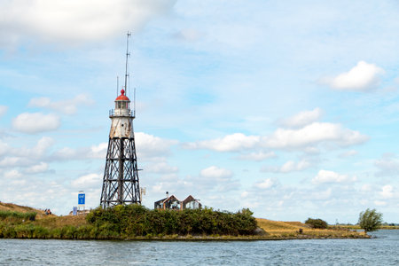 Wooden historic lighthouse near Amsterdam under Dutch blue skies.