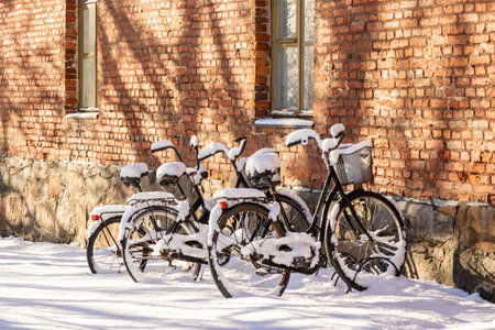 Bicycles left in a parking spot with a thick layer of fresh snow.の写真素材