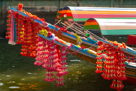 Colourful flowers hanging of the bow of traditional boat in Bangkokの写真素材