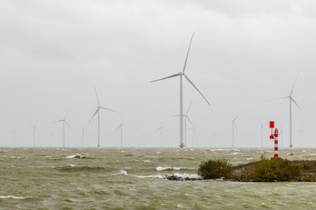 Wind turbines on a dike along a stormy lake in winter