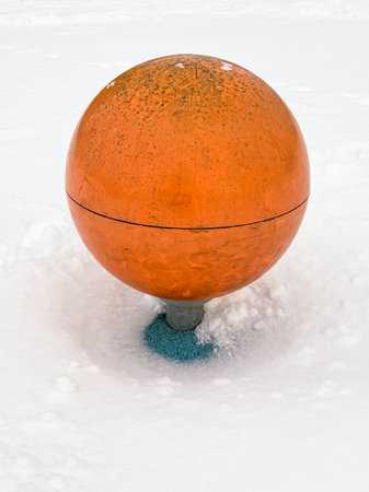 Orange plastic ball in the snow, close-up of photo.の写真素材