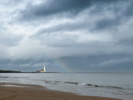 Lighthouse on the beach with a rainbow in the background, Englandの写真素材