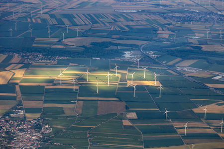 Many windmills or wind turbines for green, renewable, energy or electricity on a hilltop between colorful fields in Austria, near Vienna in warm glow of afternoon sunlight. High quality photoの写真素材