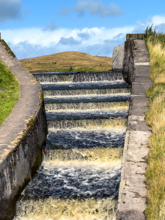 cascading water, waterfall in Scottish highlands near water reservoir, artificial lake basisの写真素材