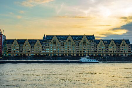 Siebengebirge building at Cologne Rheinauhafen, view fromother side of Rhiine river, sunset, cloudy skyの写真素材