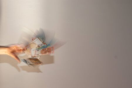 Human hand throws euro banknotesの写真素材