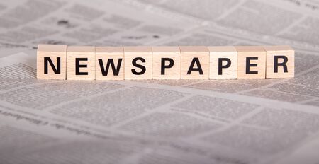 newspaper text on wooden cubes, newspaper as backgroundの写真素材