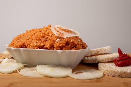 vegan spread with onions surrounded by rice waffles, onions and tomato paste, in a bowl on a wooden board, free textの写真素材