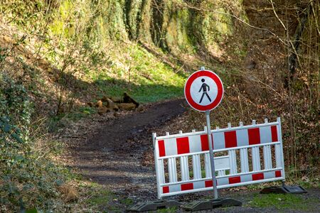 closed forest path, blocked by white and red barriedの写真素材