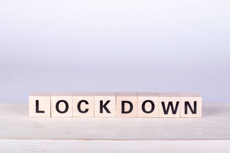 wooden cubes building the word Lockdown, white background and boardの写真素材