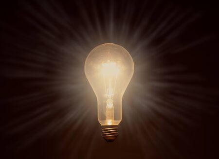 glowing light bulb against dark background, drawn stripes as rays of light, copy space
