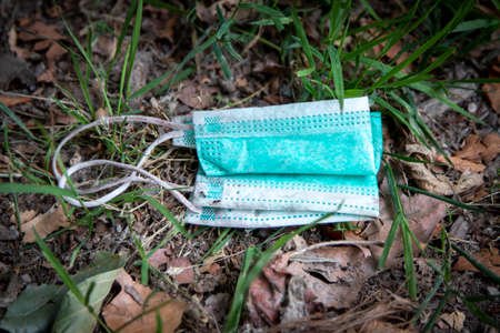 thrown away or lost mouth masks on the ground, outdoorの写真素材
