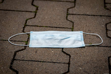 thrown away or lost mouth masks on the ground, outdoorの写真素材