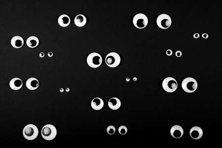 several eye couples on black background, looking into different directionsの写真素材