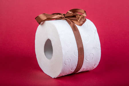 toilet paper roll with loop as present on red backgroundの写真素材
