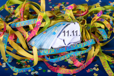 11th November covered by mouth protection and surrounded by streamers and confetti, symbol for...