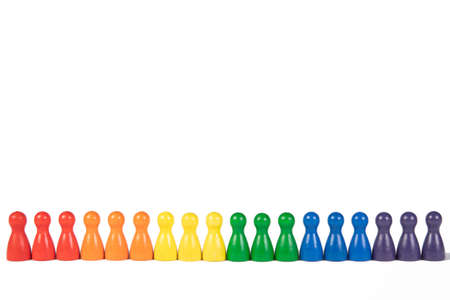 wooden figurines in a row in rainbow colors on white background, copy space