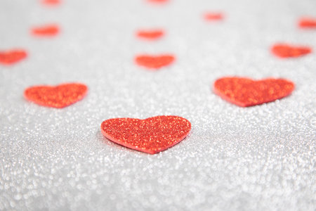 red hearts in glitter on a silver glitter background, valentine's day