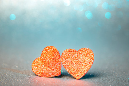 two red hearts in glitter on a silver and green glitter background, valentine's dayの写真素材
