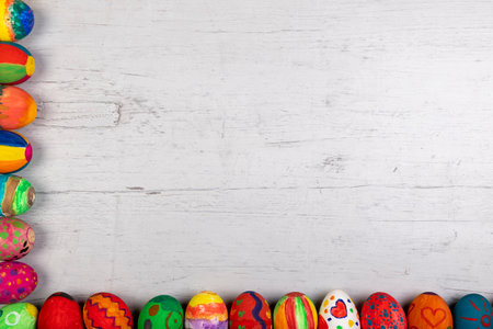 frame of painted easter eggs on a gray and white wooden board, copy spaceの写真素材