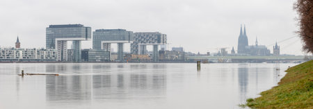 Panorama of Cologne with crane houses and Cologne cathedral at snowy weather. rhine river with high waterの写真素材