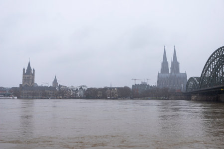 panorama of Cologne with cathedral great St. Martin and hohenzollern bridge at snowy weather. rhine river with high waterの写真素材