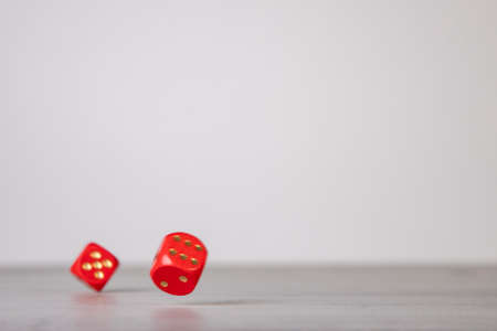 the dice have fallen, red dice falling on a gray wooden boardの写真素材