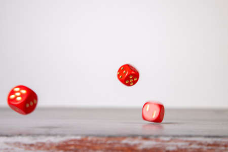 the dice have fallen, red dice falling on a gray wooden boardの写真素材