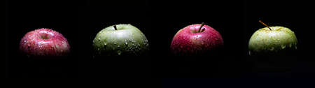 close-up of green and red apples, light from above, black background, water drops on the applesの写真素材