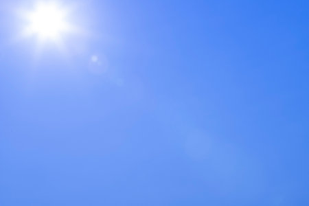 sun with beams in the blue sky as backgroundの写真素材
