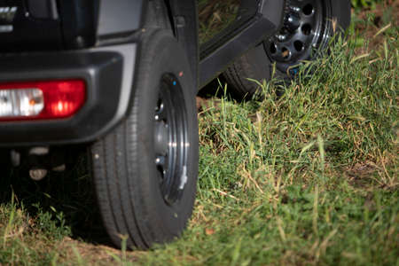 close up of a small black off-road car. It is standing in a meadowの写真素材