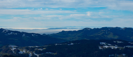 Panorama from hills in Appenzell, Switzerland, to the flatlands covered in fogの写真素材
